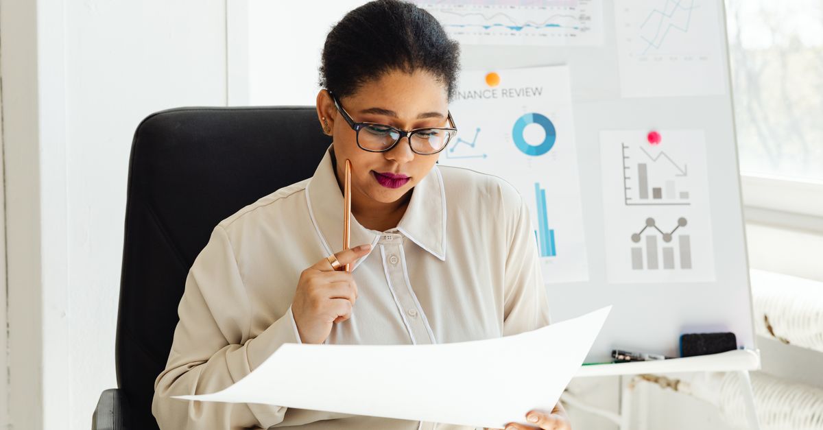 Finance professional analyzing a report in front of a finance review board