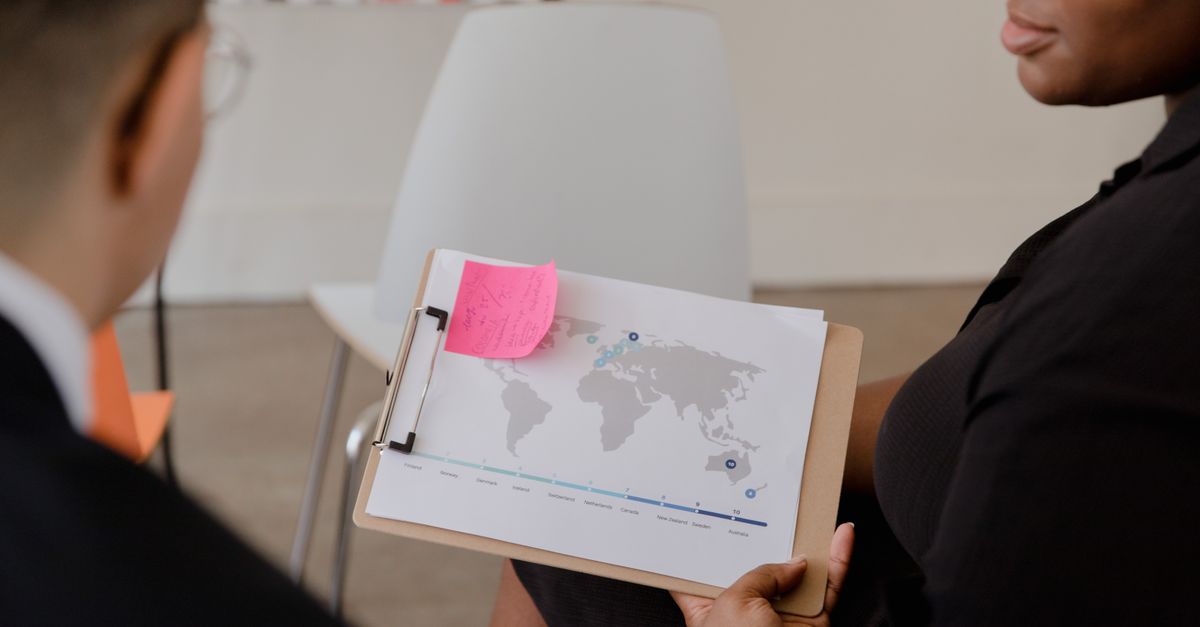 Business professionals reviewing a world map and market data report