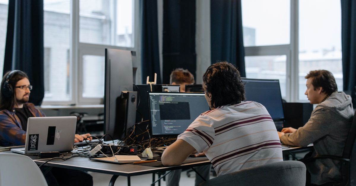 Team of developers working together at computers in a modern office
