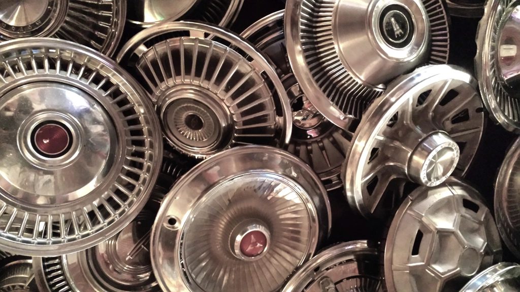 Pile of vintage car hubcaps and wheel parts