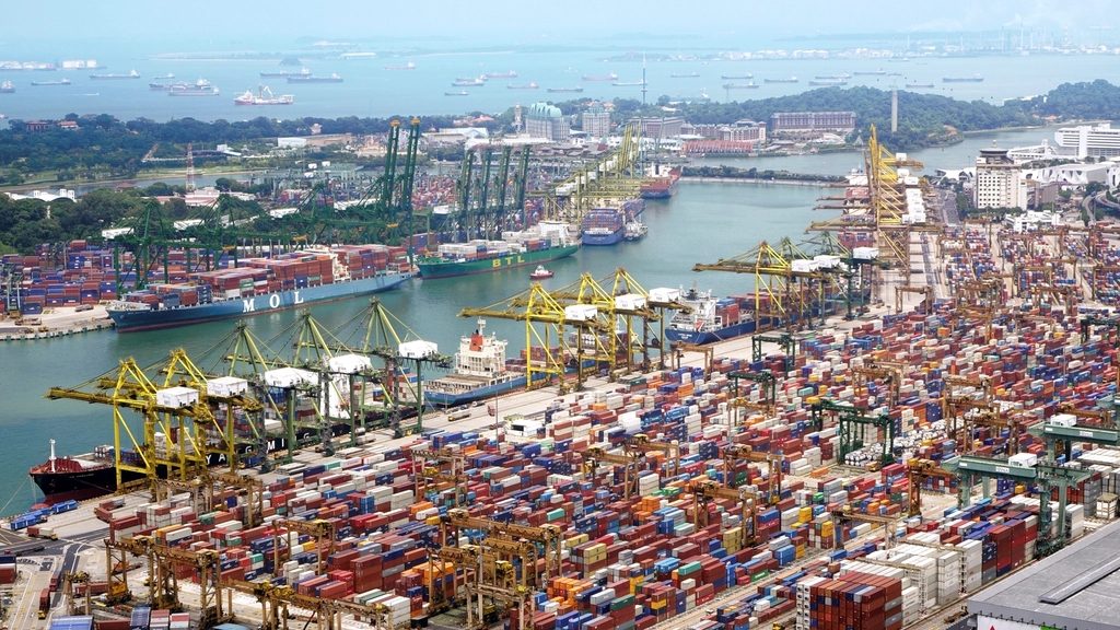 Container port with stacked shipping containers and cranes