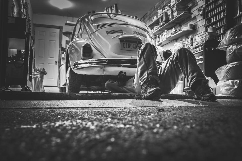 Mechanic working under a car in a workshop