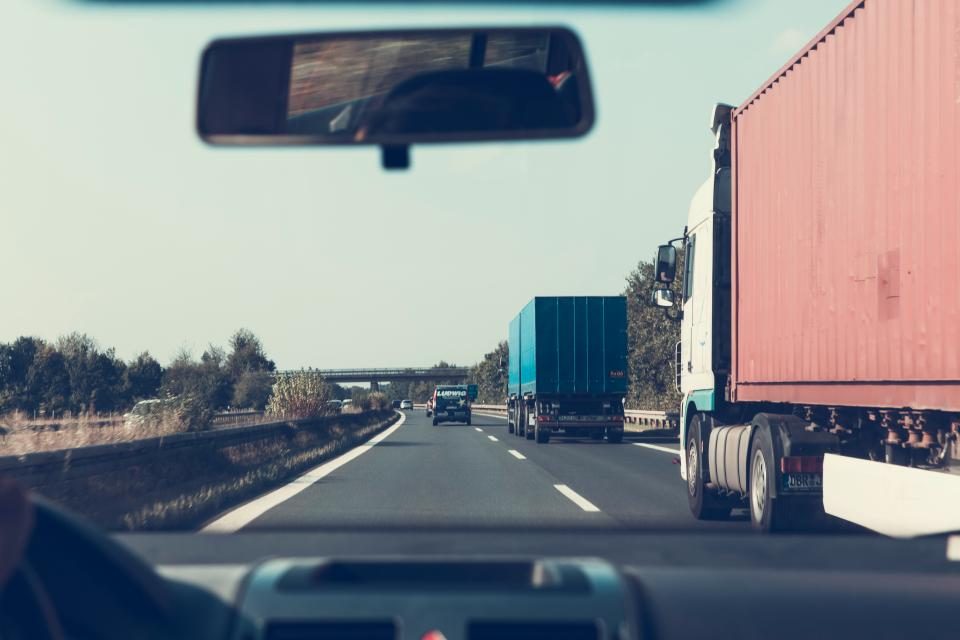 Trucks on a highway, seen from the driver's seat of a car
